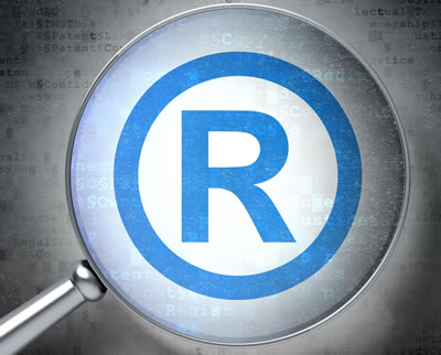 An image of the registered trademark symbol viewed under a magnifying glass.
